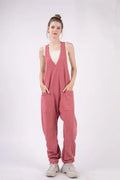 Woman wearing a pink jumpsuit on a white background