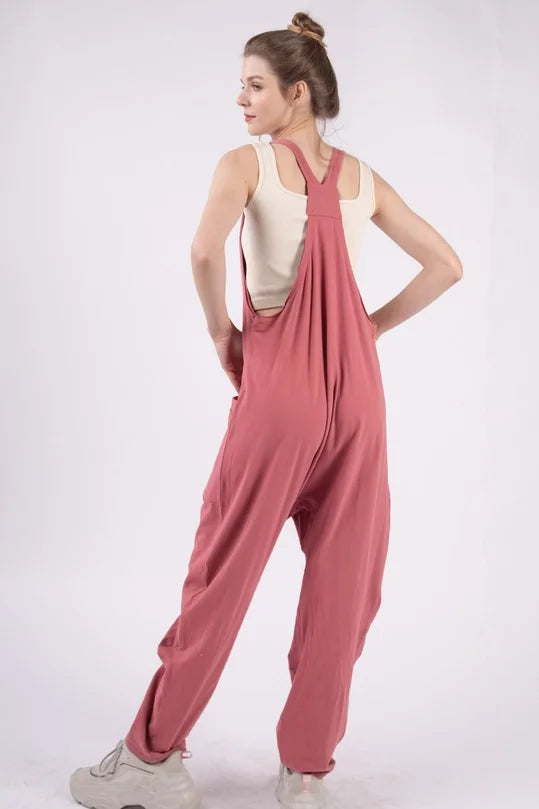 Woman wearing a pink jumpsuit on a white background